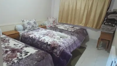 a room with two beds and a couch and a chair at Hotel Opéra Azrou in Azrou