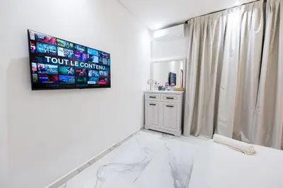 a bathroom with a white marble floor and a window at Cozy Apartment in new town in Fès