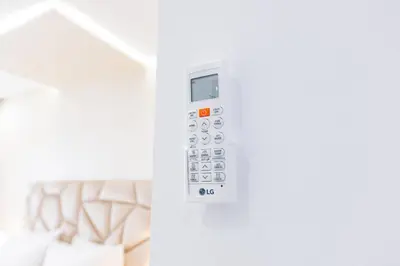 a white remote control on a white wall at Cozy Apartment in new town in Fès