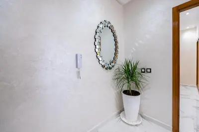 a white bathroom with a mirror and a potted plant at Cozy Apartment in new town in Fès