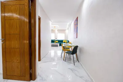 a hallway with a table and chairs and a door at Cozy Apartment in new town in Fès