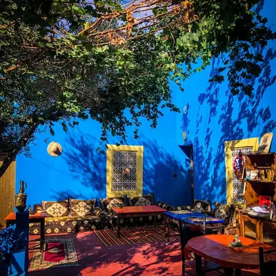 a room with a tree and a couch and tables at Dar Toda - Zagora guest house in Zagora