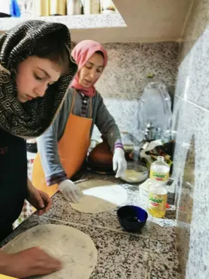 two women in a kitchen making a pizza at Dar Toda - Zagora guest house in Zagora