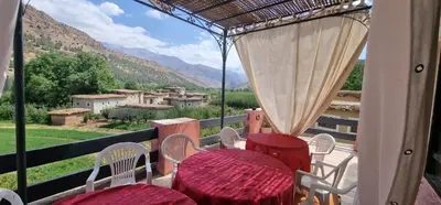 a balcony with tables and chairs and a view of the mountains at Gite Tamounte in Tabant