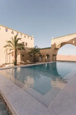 a swimming pool in the middle of a building at Sahara pearl Hotel in Merzouga