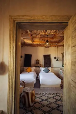 a bedroom with two beds and a couch at Sahara pearl Hotel in Merzouga