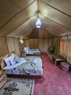 a bedroom with two beds in a tent at Najma Luxury Camp in Merzouga