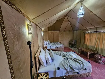 a room with two beds in a tent at Najma Luxury Camp in Merzouga