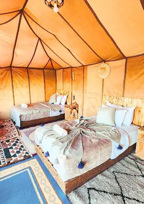 a bedroom with two beds in a tent at Najma Luxury Camp in Merzouga