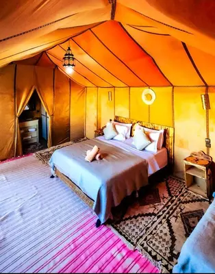 a bedroom with a bed in a tent at Najma Luxury Camp in Merzouga