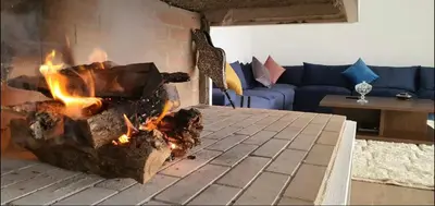 a fire in a fireplace in a living room at Villa à 30 mn de Marrakech. in El Aouina