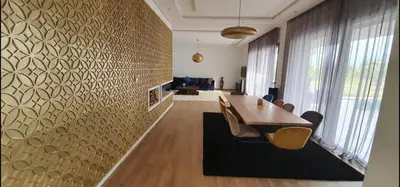 a dining room with a table and chairs and a wall at Villa à 30 mn de Marrakech. in El Aouina