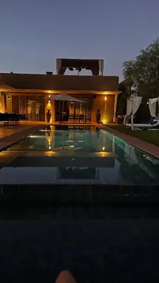 a swimming pool in front of a house at night at Villa à 30 mn de Marrakech. in El Aouina
