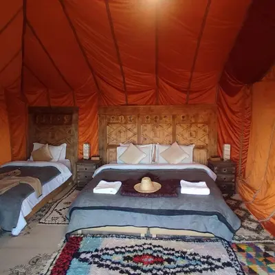 a bedroom with two beds in a tent at Overnight Luxury Camp in Merzouga