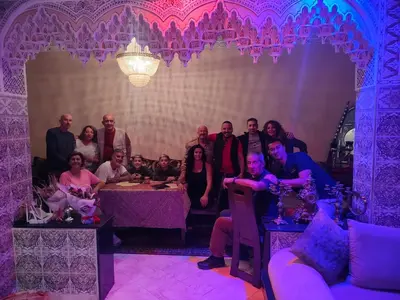 a group of people posing for a picture in a room with purple lighting at Riad Andalousse in Meknès