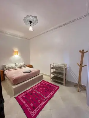 a bedroom with a bed and a red rug at Appartement In Ksar Ait Ben Haddou in Aït Ben Haddou