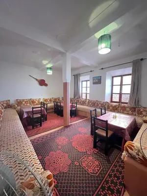 a dining room with couches and a table and chairs at Appartement In Ksar Ait Ben Haddou in Aït Ben Haddou