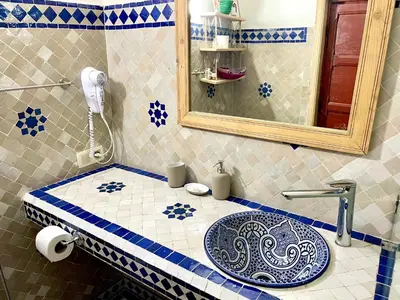 a bathroom with a sink and a mirror at Riad Noor Medina in Fès