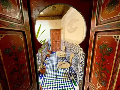 a room with a balcony with a table and chairs at Riad Noor Medina in Fès