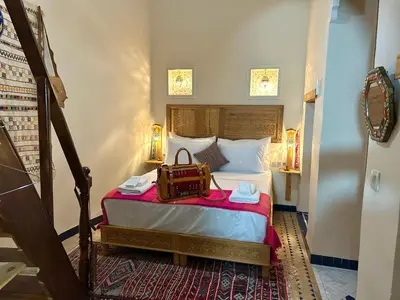 a bedroom with a bed with a bag on it at Riad Noor Medina in Fès
