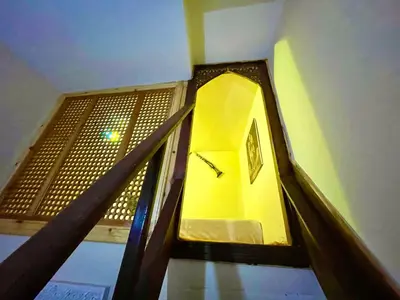a stairway with a yellow clock in a building at Riad Noor Medina in Fès