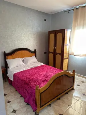 a bedroom with a large bed with a red blanket at HOTEL NOSTRESS in Khenifra