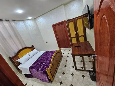 a bedroom with a bed and a table and a television at HOTEL NOSTRESS in Khenifra