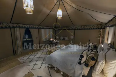 a room with a tent with a bed in it at Merzouga Spirit Luxury Camp in Merzouga