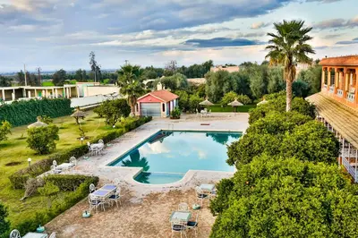 an overhead view of a pool with chairs and a house at Complexe El Bassatine in Beni Mellal