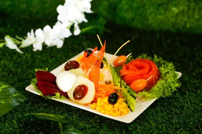 a plate of food with vegetables on the grass at Complexe El Bassatine in Beni Mellal