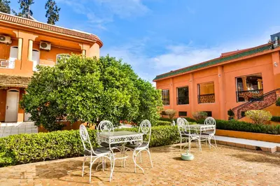 a group of chairs and a table in front of a building at Complexe El Bassatine in Beni Mellal