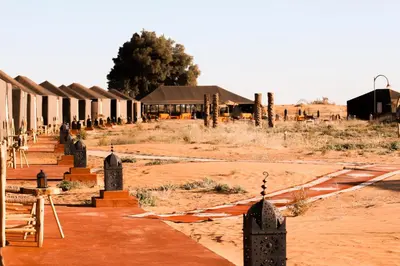 a group of buildings in the desert with a dirt field at Gorgeous Luxury Camp in Merzouga