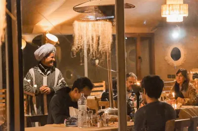 a group of people sitting at a table in a restaurant at Gorgeous Luxury Camp in Merzouga