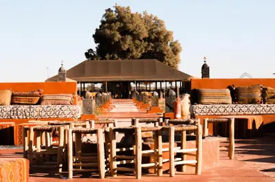 a group of tables and chairs in front of a building at Gorgeous Luxury Camp in Merzouga