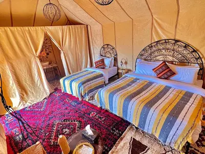 a bedroom with two beds in a tent at Gorgeous Luxury Camp in Merzouga