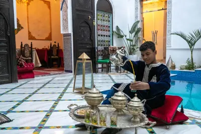 a boy sitting in a room with a tray of food at Palais Chahd Luxury in Fès