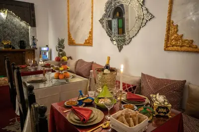 a table with food and a bottle of wine on it at Palais Chahd Luxury in Fès