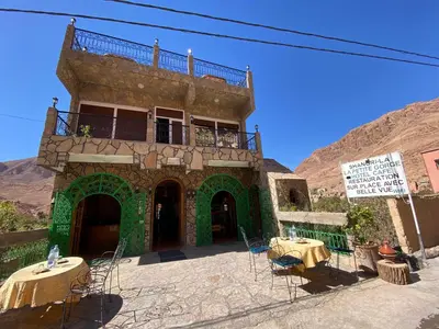 a building with tables and chairs in front of it at La Petite Gorge, Hôtel & Restaurant Todra Gorge in Tinerhir