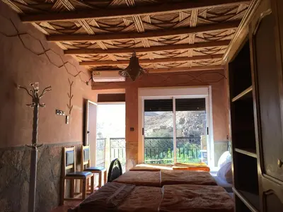 a bedroom with a bed in a room with a window at La Petite Gorge, Hôtel & Restaurant Todra Gorge in Tinerhir