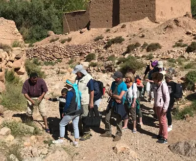 a group of people walking on a mountain at La Petite Gorge, Hôtel & Restaurant Todra Gorge in Tinerhir