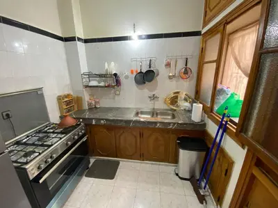 a small kitchen with a stove and a sink at Cozy apartment near city center in Fès