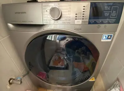 a washing machine with a reflection in the front of it at Cozy apartment near city center in Fès