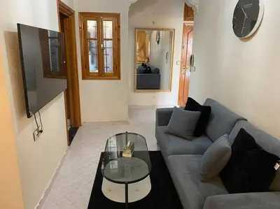 a living room with a couch and a glass table at Cozy apartment near city center in Fès