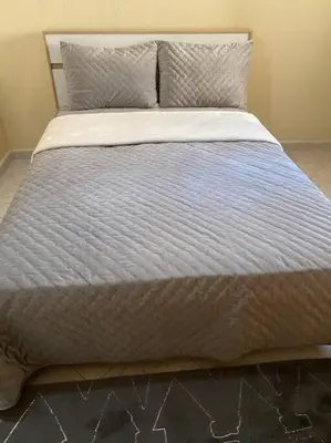 a large bed with a white comforter and pillows at Cozy apartment near city center in Fès
