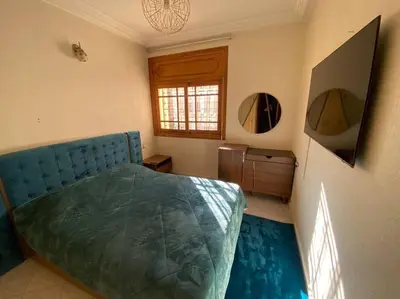 a bedroom with a blue bed and two mirrors at Cozy apartment near city center in Fès