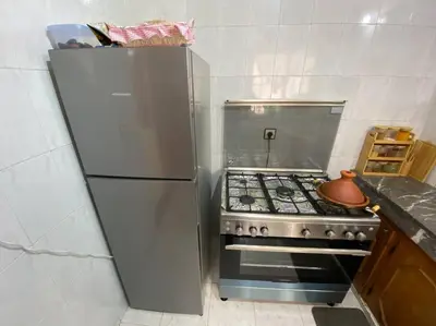 a kitchen with a stainless steel refrigerator and a stove at Cozy apartment near city center in Fès