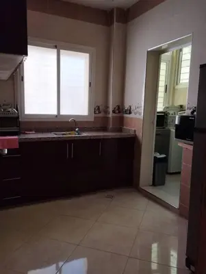 a large kitchen with a sink and a window at Bel appartement calme est bien équipé in Meknès