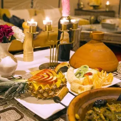 a table topped with a plate of food and candles at Merzouga desert Luxury Camp in Merzouga