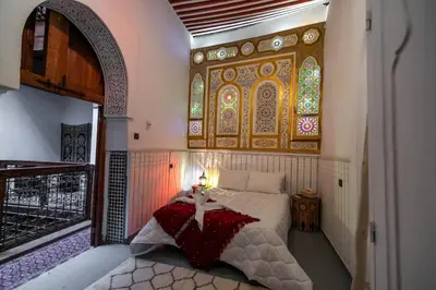 a bedroom with a bed and a stained glass window at RIAD DAR DIWAN in Fès