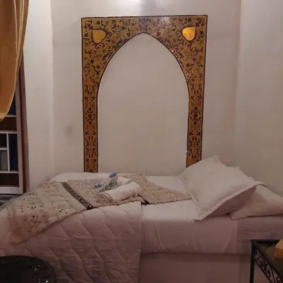 a bed with an ornate frame in a room at RIAD DAR DIWAN in Fès